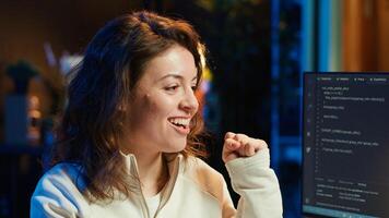 Delighted programmer celebrating after filtering malicious traffic from cybercriminals attempting to steal company data. Woman excited about accomplishment, preventing malware, camera A photo
