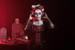 Woman wearing headphones, hearing songs at Day of the Dead event to remember the deceased. Lady listening music during Mexican holiday of remembrance for those who have passed photo