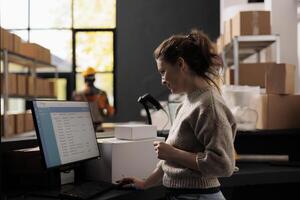 Stockroom supervisor analyzing merchandise checklist on computer, working at products inventory report in warehouse. Storage room supervisor standing at counter desk checking goods logistics photo