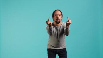 Irked man fighting with friend, doing middle finger sign gesturing, isolated over studio background. Outraged person arguing during conversation, doing obscene hand gestures, camera A photo