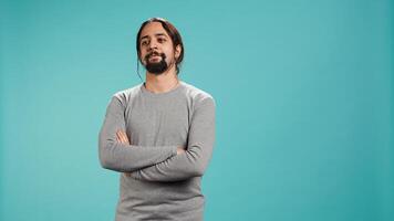 Portrait of cheerful Arab man smiling, looking pleased, isolated over blue studio background. Happy expressive person stylishly dressed grinning, feeling satisfied, camera B photo