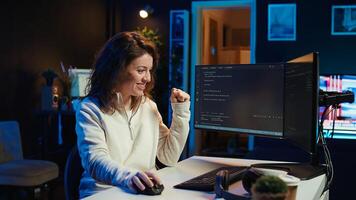 Joyous woman doing software quality assurance celebrating after reading source code and finding no errors. Cheerful engineer excited after inspecting coding on desktop PC, seeing no issues, camera B photo