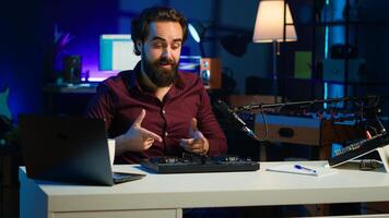 Artist filming DJ mixing tutorial, showing examples of sampling on sound controller to viewers. Viral online star showing modern musical equipment to subscribers in home studio, camera A photo