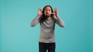Portrait of spiteful man making exaggerated silly faces, mimicking someone, doing mocking gesturing. Person making goofy facial expressions, being playful, making fun, studio background, camera A photo