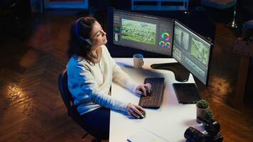 Freelancer adds sound effects to filmed footage, working in home studio. Post production specialist using headphones to test and improve audio quality using editing application, camera B photo
