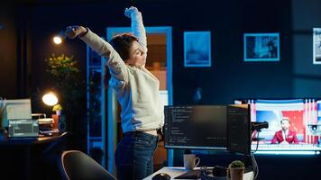 Programmer stretches body limbs after securing company servers from virus attacks all day. Fatigued IT remote employee relaxing tense muscles at desk after building firewalls protecting data, camera A photo