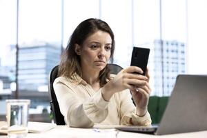 Female CEO discussing business ideas with her team on social media, receiving project updates form employees via text messages. Successful goal oriented entrepreneur with determination. photo