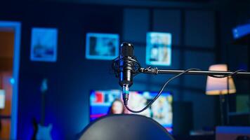 Streaming microphone equipment used to record discussions for internet livestreaming channel, close up. Jib down shot of sound capturing and recording gear in empty living room with neon lights photo
