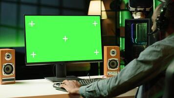 Gamer using headphones to discuss with mates while playing online videogame on isolated screen monitor. Man enjoying coop game with friends on mockup computer display, chatting on internet photo