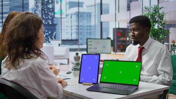 Team of recruiters interviewing job applicant with a green screen on desk, discussing about potential career development plans and his aspirations. Women attend an interview with candidate. Camera B. photo