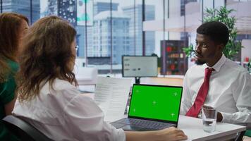 HR manager doing a job interview with candidate by using laptop with chroma key mockup, asking questions about his studies and qualifications. Businesswoman meeting with applicant. Camera B. photo