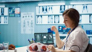 Female doctor and patient engage in a medical consultation for a scan interpretation of x ray results. Physician specialist emphasizing modern healthcare practices and medical research. Camera B. photo