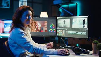 Upbeat videographer reviewing footage and selecting scenes, trimming using specialized software applications and editing tools. Smiling editor working for media company in editing room, camera B photo