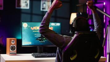 Man feeling happy while playing science fiction videogames on computer desktop, celebrating victory. Cheerful gamer overjoyed after winning game on gaming PC, close up, camera A photo