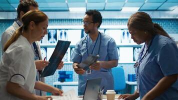 Physicians and radiologists analyzing x ray scans to create an effective treatment plan. Medics doing teamwork at a private clinic to ensure radiography based diagnostics for healthcare. Camera B. photo