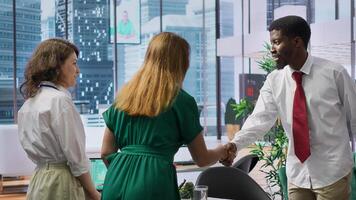 HR recruiters team greeting a job candidate at an interview with a handshake, professionals reviewing the work experience based on the resume information. Interviewers seeking talent. Camera A. photo