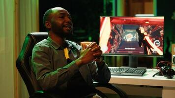 African american man teaching subscribers professional esports skills and how to play game. Media star on gaming chair chatting with viewers, filming gaming tutorial, camera A photo