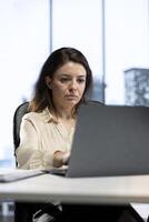 Confident female leader driven by empowerment and ambition, focuses on achieving business targets and enhancing company performance in a dynamic office setting. Leadership success story. photo