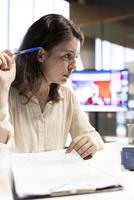 Female leader signing legal management documents and contracts, giving her authorization for license agreements and leave requests from employees. CEO deals with paperwork in office. photo