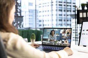 Determined female CEO leads a videoconference meeting with shareholders, encouraging open communication, idea sharing and a new investment plan to work on global expansion. Achieve common goals. photo