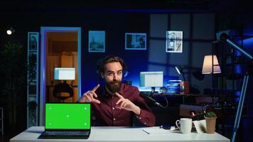 Entertainer presents chroma key laptop from brand sponsoring , analyzing features. Content creator reviewing green screen notebook for technology enthusiasts, inspecting materials, camera B photo
