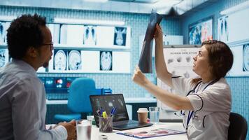 General practitioner consults patient about diagnostic test results, utilizing medical technology for analysis and patient care management in a clinical environment. Healthcare provider. Camera B. photo