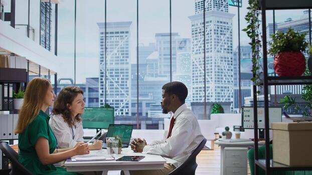 Recruitment team conducts an interview with a professional job applicant, evaluating their resume and discussing their background. HR employees addressing a series of questions. Camera B. photo