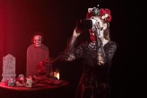 Woman using virtual reality technology at Day of the Dead event to remember the deceased. Lady using VR headset during Mexican holiday of remembrance for those who have passed photo