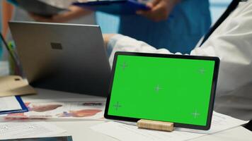 Licensed doctor and his staff review x ray scan results next to isolated copy space screen, examining hospital records before putting a diagnosis. Consulting analytics and radiography. Camera A. photo