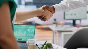 Recruitment team shaking hands with a new job candidate before an interview, greeting job seeker in a high end office. Headhunters interviewing young man with a great CV. Close up. Camera A. photo
