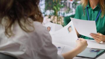 Human resources staff evaluating candidates resume in the selection process, reviewing all applicants after job interview in order to hire the right person. Recruiters seeking personnel. Camera A. photo