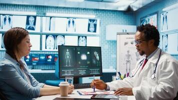 Medical expert discussing about diagnostics treatment with patient in cabinet, reviewing the test analysis reports during a consultation. Medic specialist supporting woman with illness. Camera B. photo
