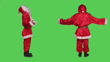 Santa claus confused on greenscreen, doing i dont know sign and feeling clueless in studio. Father christmas in suit acting uncertain and unsure about answer, doubtful character shrugging. photo