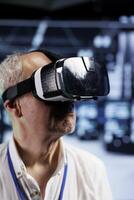 Close up of admin immersed in virtual reality at data center, doing machines maintenance. Employee using VR headset to optimize server racks system performance, harnessing cutting edge technology photo