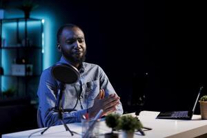 Entertainer using professional mic to record himself chatting with internet audience. Content creator discussing with viewers during live broadcast stream, using high quality audio equipment photo