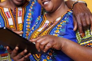 Woman hand tapping on digital tablet touchscreen while hugging with man closeup. African american romantic couple using portable gadget and scrolling internet on screen close view photo