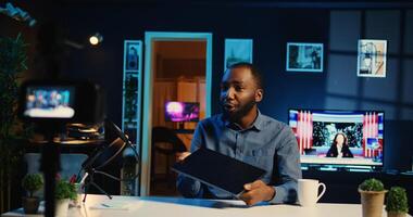 Internet star films review of newly released laptop, unboxing it and presenting specs to audience. Influencer showing ultra slim notebook to viewers, offering feedback of its performance photo