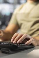Accountant typing on keyboard, imputing revenue figures on computer in office. Close up of man at desk focused on typing company statistical numbers, working hard to finish job before deadline photo