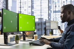 Man checking paperwork details on mockup PC screen, solving tasks. Bookkeeper in office making sure documents are compliant with quality assurance standards using green screen computer photo