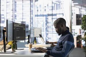Computer technician doing software quality assurance, reading source code on computer before implementing it. IT admin inspecting coding on PC device, looking to fix potential issues photo