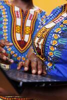 Black man and woman using laptop and scrolling internet page with touchpad closeup. African american couple holding fingers on portable computer close view while typing message photo