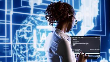 Inspector overseeing data center updating AI systems, writing intricate binary code scripts on laptop. Skilled IT practitioner using programming to upgrade artificial intelligence simulation model photo