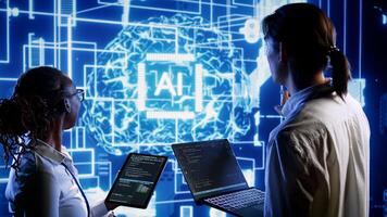 Teamworking colleagues updating AI systems, writing intricate binary code scripts on tablet and laptop. Qualified engineers using programming to upgrade artificial intelligence simulation model photo