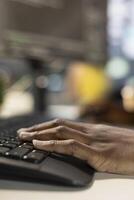 Employee on computer writing emails, solving tasks. Close up of bookkeeper typing on keyboard in office, making sure documents are compliant with quality assurance expectations and standards photo