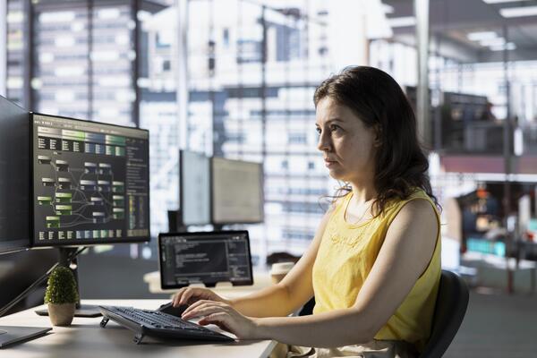 Programmer creating complex machine learning models that can process and analyze vast amounts of data to improve and automate decision making processes. Woman programming in office