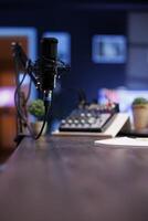 Podcast microphone for live streaming used to record content discussions for internet channels. Closeup of professional mic used for live online talk shows, broadcasted in a home studio. photo
