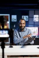 African american man filming tech tutorial on how to do replace keycaps on broken keyboard. Technology internet show host teaching subscribers how to mend computer peripheral photo