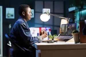African american woman and man collaborate remotely through virtual communication on laptop. They are engaged in a call, discussing and utilizing technology for their work from home. photo