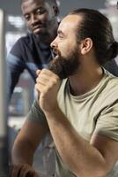 Employee laughing at coworker joke while analyzing datasets, checking accounting figures on computer. Funny worker amusing colleague while solving tasks for team project at workplace photo