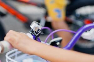 Close-Up of Child's Hand on Purple Bicycle Handlebar photo